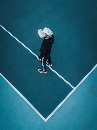 身穿运动服、头戴VR耳机的男子站在网球场上